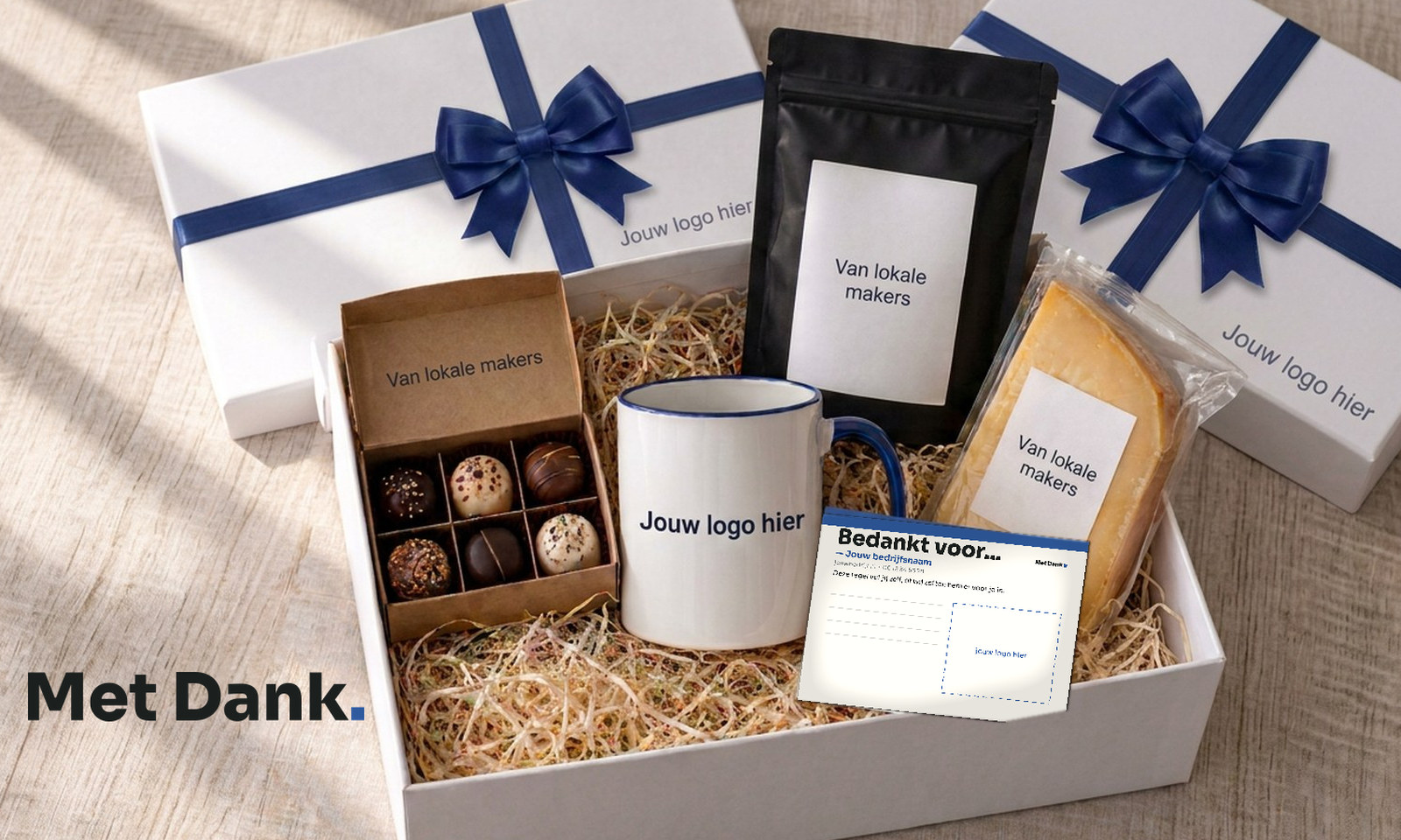Two white gift boxes with navy ribbon and bow; the open box shows a mug, chocolates, coffee, cheese and a card